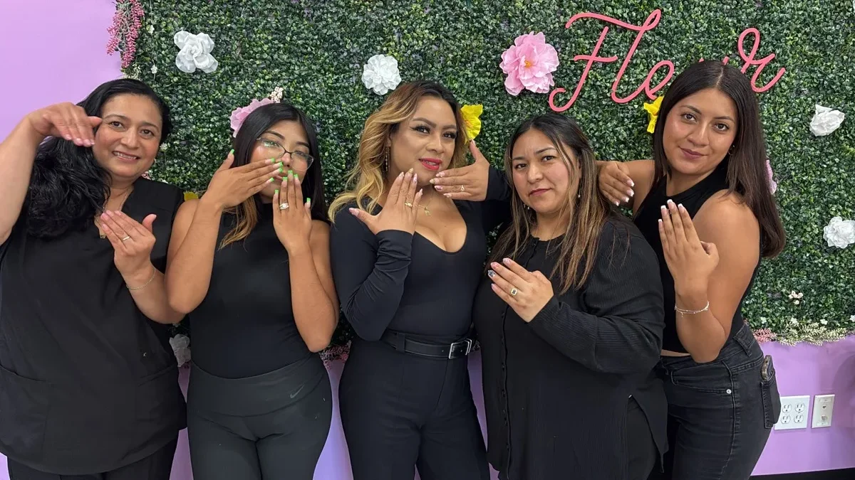 The Nail Queen team showing off their nails at the flower wall